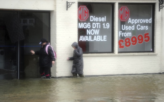 Dos mujeres se abren paso a través de una calle inundada en Datchet, cerca de Londres. Foto: EFE