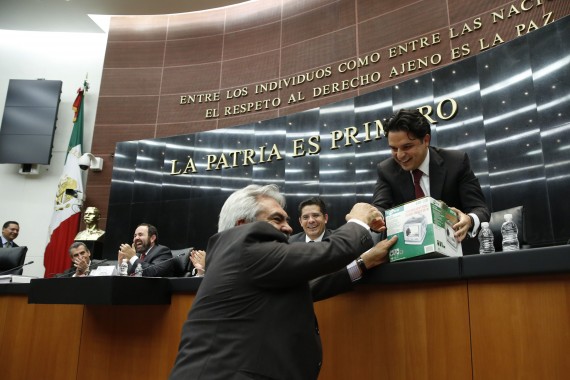 El Senador perredista Zoé Robledo le regala una televisión al priista José Orihuela. Foto: Cuartoscuro
