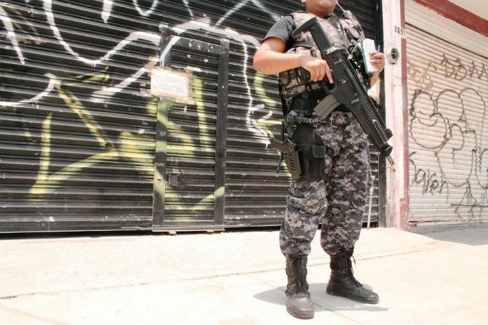 Uno de los tres guardias armados de la policía que patrullan la tienda noche y día. Foto: Victor Hugo Ornelas/MOTHERBOARD