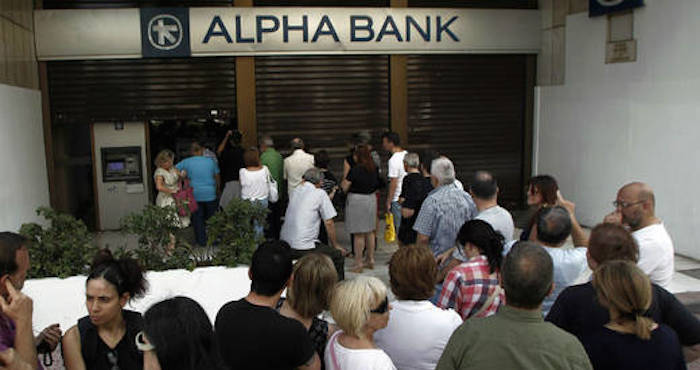 Tras el anuncio del Primer Ministro de Grecia de que el lunes permancerán cerrados los bancos, cientos de personas hacen fila en los para sacar dinero. Foto: EFE
