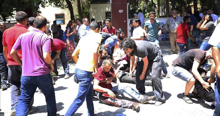 Varias personas tratan de auxiliar a los heridos tras producirse la explosión de un artefacto en un centro cultural en Suruc, provincia de Sanliurfa,Turquía. Foto: EFE