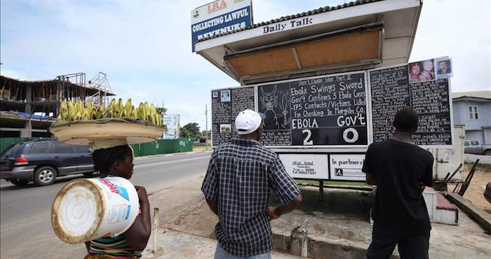 Personas leen unas instrucciones sobre el Ébola en una calle de Monrovia, Liberia. Foto: EFE