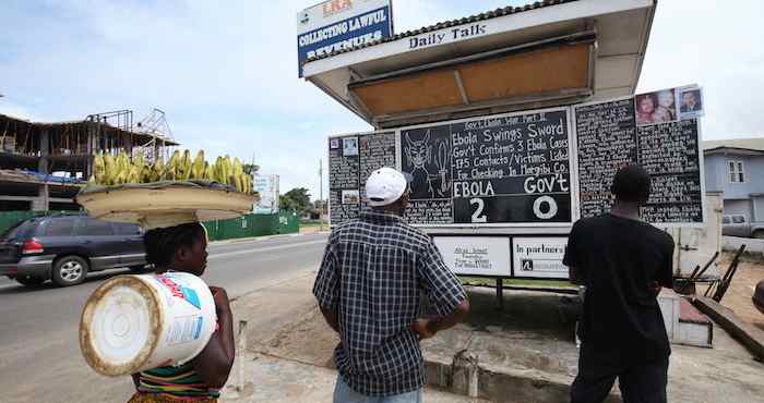 Personas leen unas instrucciones sobre el Ébola en una calle de Monrovia, Liberia, el pasado 10 de julio. Foto: Efe