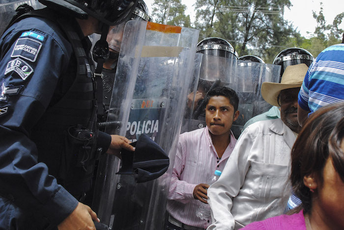 Sin poner resistencia, los vecinos e integrantes de la APPG comenzaron a replegarse a las banquetas y el camellón. Foto: Cuartoscturo