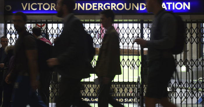 Peatones caminan junto a una entrada de metro cerrada en Londres (Reino Unido). Foto: EFE
