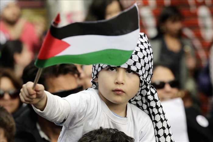 Un niño de la comunidad Palestina en Chile sostiene una bandera. Foto: Efe
