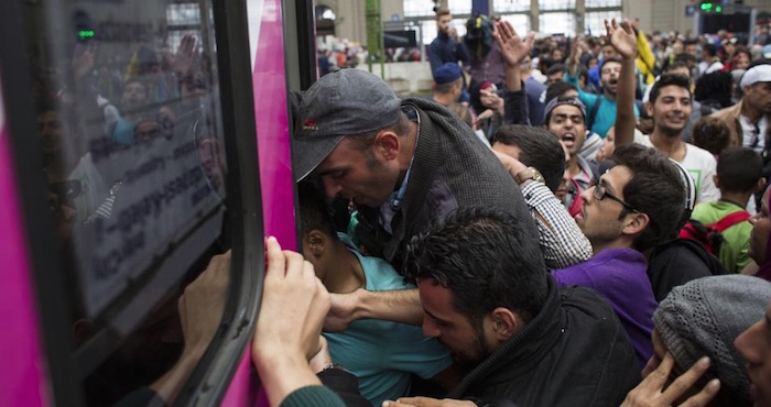 Muchos padres de familia aguantan en las puertas de los trenes e intentan alcanzar a los suyos con los brazos entre un océano de personas. Foto: Matthew Cassel, VICE Media