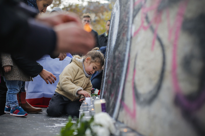 Una niña enciende velas en altar a las víctimas de los atentados terroristas. Foto: Xinhua  