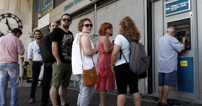 Varias personas hacen cola para retirar dinero de un cajero automático en una sucursal del Banco Nacional de Grecia, en Atenas. Foto: EFE