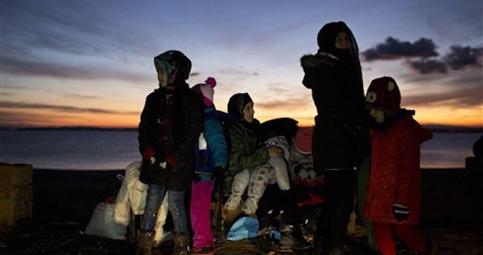 En esta fotografía una madre afgana carga a su bebé después de llegar desde Turquía a las costas de la isla griega Chios, en un barco lleno de refugiados y migrantes. Foto: AP