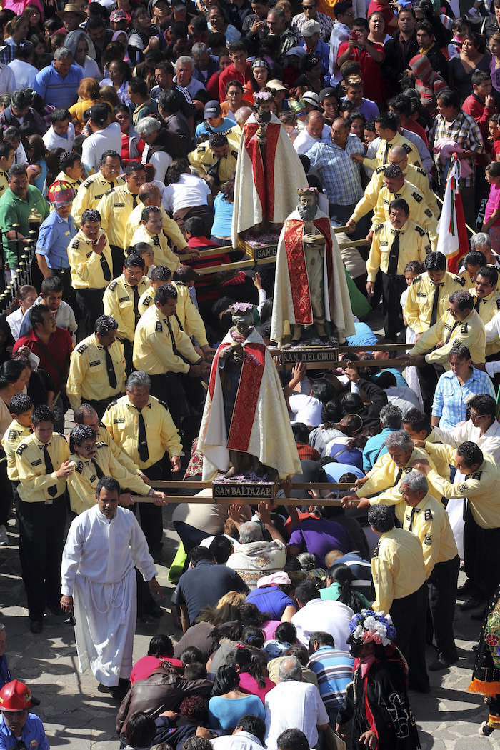 Las personas se adelantan al paso de los Reyes para arrodillarse ante ellos y permitir que pasen por encima en un trayecto que dura más de tres horas. Foto: Cuartoscuro