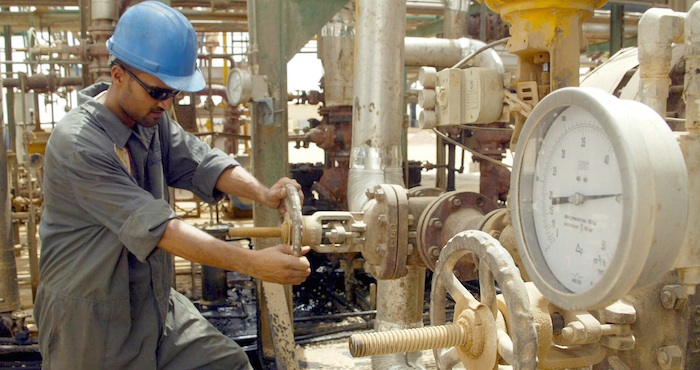 Un operario abre una válvula en una refinería. Foto: EFE.