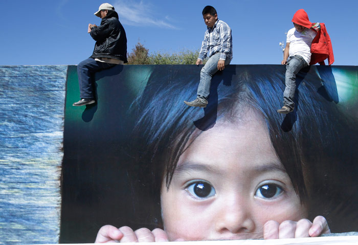 Gente desde lo alto de un gran cartel escuchan al Papa Francisco que oficia una misa en San Cristóbal de las Casas, México. Gregorio Borgia, AP