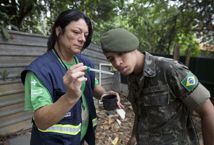 Una funcionaria de la secretaría de Salud Pública de Sao Paulo muestra a un soldado larvas del mosquito Aedes aegypti Foto: AP