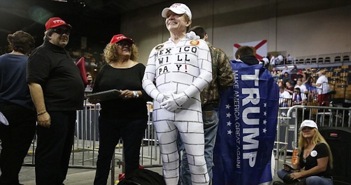 Un hombre porta un atuendo en apoyo a la propuesta de muro fronterizo de Donald Trump. Foto: AP.
