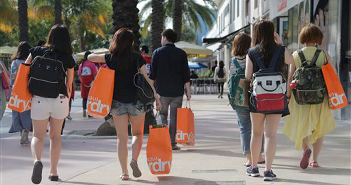 En esta foto del 3 de febrero de 2016, turistas taiiwanesas con bolsas de compras caminan por una zona peatonal de Miami Beach, Florida. La economía estadounidense registró un crecimiento levemente mayor que lo calculado en el cuatro trimestre, impulsada por el gasto de consumo, que a la vez podría darle mayor impulso en el actual período ener-marzo, informó el Departamento de Comercio el viernes 25 de marzo de 2016. Foto: Lynne Sladky), AP
