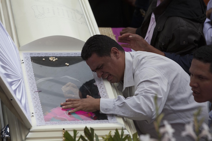 Gustavo Cáceres sobre el féretro de su hermana. Foto: Xinhua