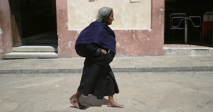 Una mujer camina descalza en calles de San Cristóbal de las Casas, Chiapas. Foto: Cuartoscuro.