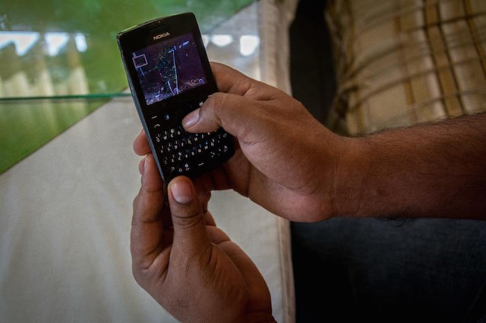 El comisario Eduardo Macedo revisa su teléfono y recuerda con nostalgia el pueblo de que fue expulsado. Foto: Daniel Ojeda/VICE.