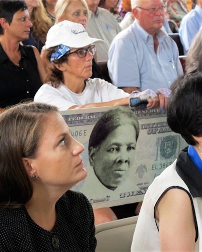 En esta foto del 31 de agosto del 2015, una mujer lleva un cartel en respaldo a colocar la imagen de Harriet Tubman en el billete de 20 dÛlares durante una reuniÛn en Seneca Falls, Nueva York. Un funcionario del Departamento del Tesoro dijo el miÈrcoles, 20 de abril del 2016, que el secretario habÌa decidido poner a Tubman en el nuevo billete e 20, lo que la har· la pirmera mujer en papel moneda en Estados Unidos en 100 aÒos. (Foto AP/Carolyn Thompson)