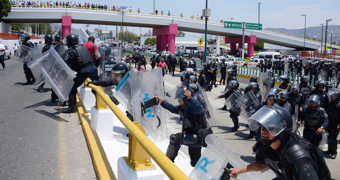 Policías estatales y federales con equipos antimotines encapsularon a los manifestantes y pidieron que se abriera la vialidad de la autopista. Foto: Cuartoscuro.