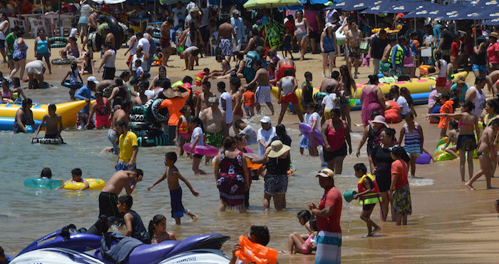 Vacacionitas disfrutan los últimos días de vacaciones de Seamana Santa en la playa, Caletilla en el Puerto de Acapulco. Foto: Jesús Trigo, El Sur.