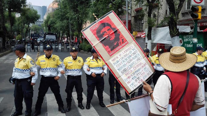 Elementos de seguridad vigilan la marcha de los maestros disidentes. Foto: Luis Barrón, SinEmbargo