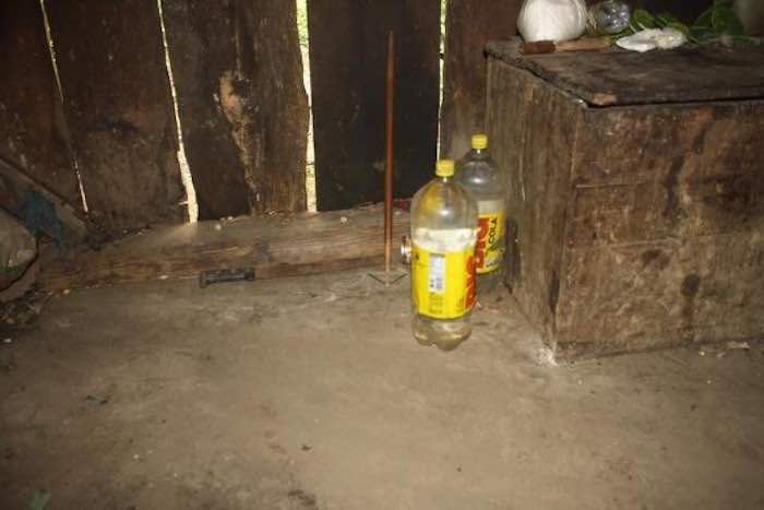 En la imagen se observan un par de botellas que don Macario utiliza para recolectar agua pluvial. Están en el piso, misma superficie que vio nacer y morir a sus hijos. Foto: BlogExpediente.