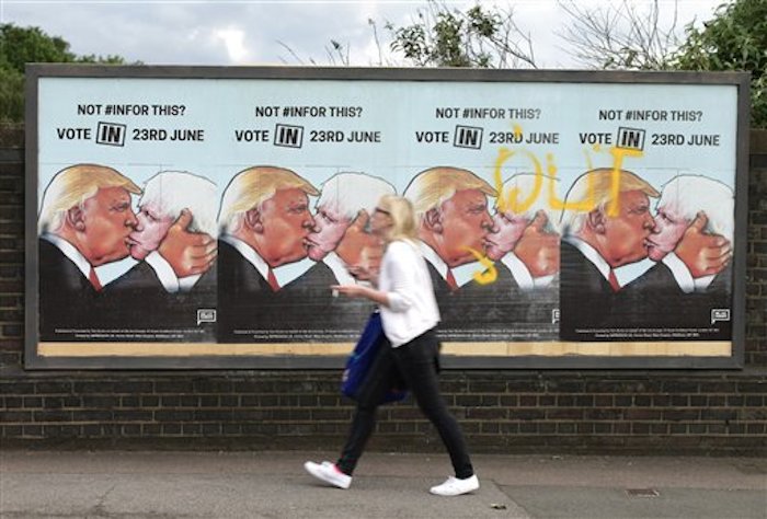 Una mujer camina frente a carteles a favor de votar por la permanencia de Gran BretaÒa en la UniÛn Europea, en Londres, 21 de juniio de 2016. En el cartel aparece el candidato republicano estadounidense Donald Trump besando al principal partidario de la salida brit·nica, Boris Johnson. (Yui Mok / PA via AP) UNITED KINGDOM OUT - NO SALES - NO ARCHIVES
