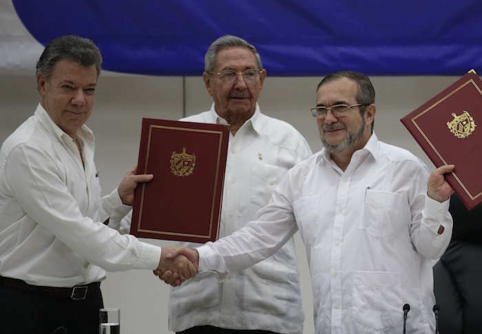 El Presidente de Colombia, Juan Manuel Santos, a la izquierda, de Cuba, Raúl Castro, en el centro, y el comandante de las Fuerzas Armadas Revolucionarias de Colombia (FARC) "Timoleón Jiménez" durante la ceremonia de firma de un acuerdo de cese del fuego bilateral y definitivo y el desarme de los rebeldes colombianos en La Habana. Foto: AP