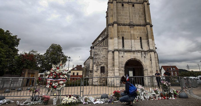 Varias personas rinden tributo en un monumento improvisado al sacerdote Jacques Hamel. Foto EFE