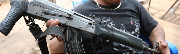Un sicario presume su kalashnikov durante el desayuno. (Imagen por Falko Ernst/VICE News)