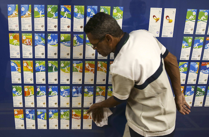 BRA08 RÕO DE JANEIRO (BRASIL), 20/05/16.- Un hombre limpia el exhibidor donde se encuentra expuestos las entradas para los Juegos OlÌmpicos y ParalÌmpicos que tendr·n lugar el prÛximo agosto y septiembre en la "ciudad maravillosa" de RÌo de Janeiro, hoy viernes 20 de mayo de 20'16. Los Juegos OlÌmpicos contar·n con 42 deportes en su programaciÛn y 23 en los ParalÌmpicos. EFE/ Antonio Lacerda