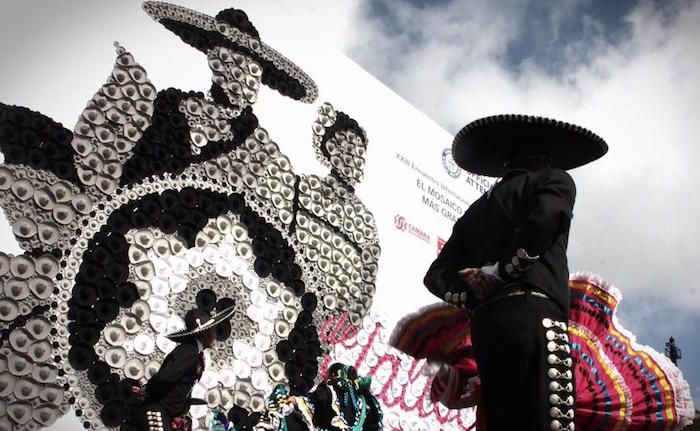 Los sombreros de charro, de colores negro, gris y blanco, fueron colocados durante varios días en un mural de 14 metros de altura para formar la figura de dos personas vestidas con trajes típicos mexicanos unidas por un gran sombrero de charro. Foto: Xinhua