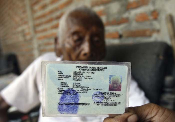 Sodimejo alias "Mbath Gotho", de 145 años de edad, muestra su carné de identidad en el que aparece su fecha de nacimiento, 31 de diciembre de 1870, durante una entrevista en su casa en Sragen (Indonesia). Foto: Efe
