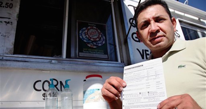 Carlos Zamora muestra un formato para registrarse para votar. Foto: AP/John L. Mone