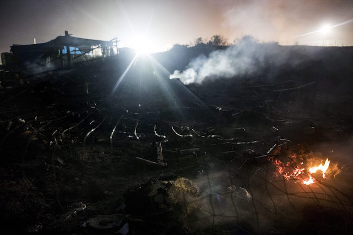 Chabolas arden mientras migrantes abandonan el campamento. Foto: EFE