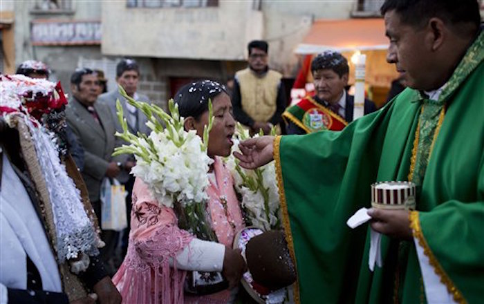 Indígena recibe la comunión en una misa comunitaria. Foto: AP/Juan Karita.