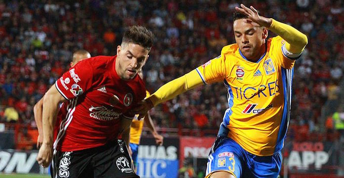 El jugador Junior Vendrechovski de Tigres y Gabriel Hauche de Xolos Tijuana disputan el balón durante el juego de la jornada 16 del fútbol mexicano en el estadio Agua Caliente de la ciudad de Tijuana. Foto: EFE.