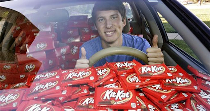 FotografÌa del 3 de noviembre de 2016 de Hunter Jobbins, estudiante de la Universidad Kansas State, mientras posa en su automÛvil con casi 6.500 barras de chocolate Kit Kat en Manhattan, Kansas. (Colin E. Braley/AP Images for The Hershey Company)