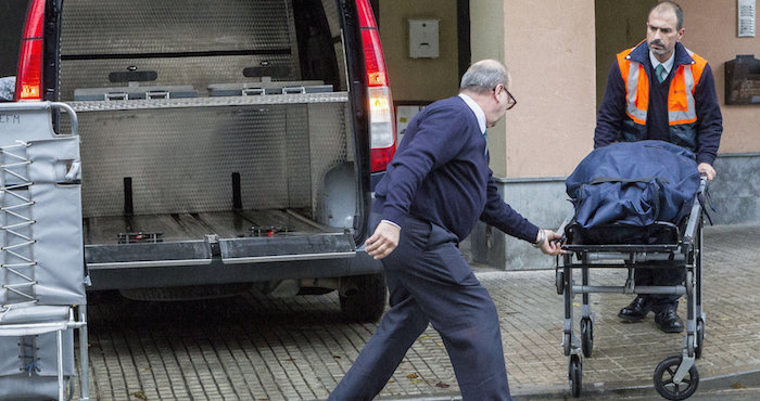 Miembros de los servicios funerarios trasladan los restos mortales de la mujer de 40 años, fallecida en su piso. Foto: EFE