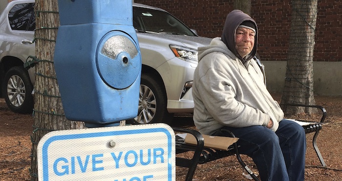 Un indigente que dijo llamarse Joe Drury descansa cerca de un aparato con la firma de un parquímetro y que está habilitado para recibir limosnas para los indigentes, en Annapolis, Maryland. Foto: AP