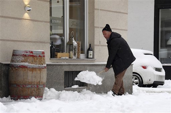 Un hombre palea la nieve en una calle en Munich, Alemania. Foto: AP.