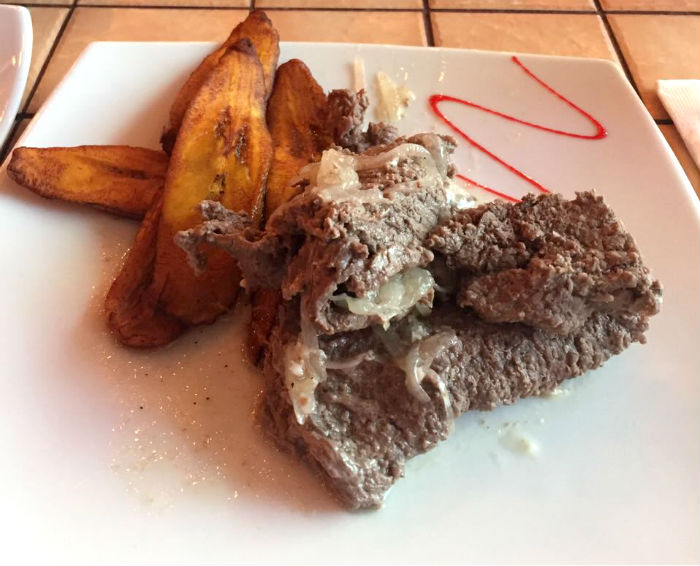 Un bistec encebollado con platanitos fritos. Foto: Cortesía para SinEmbargo