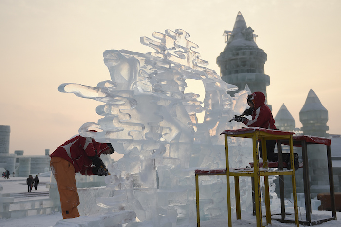Dos participantes tallan una escultura de hielo durante el concurso de esculturas. Foto: Xinhua.