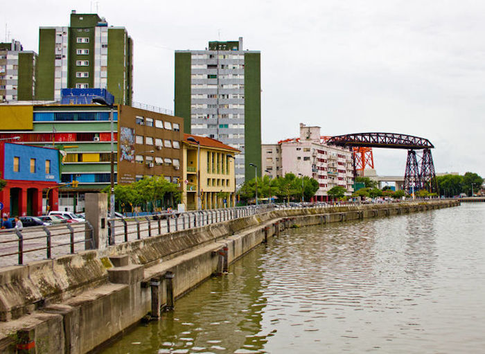 El Riachuelo a su paso por el barrio de La Boca con el Puente transbordador al fondo. Foto: Viajar Ahora/ElDiario.es