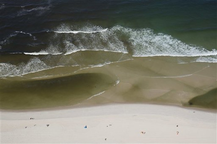 Agua contaminada, a la izquierda, que fluye desde el canal de la Barra hacia la playa de Barra en Río de Janeiro, Brasil. Foto: AP