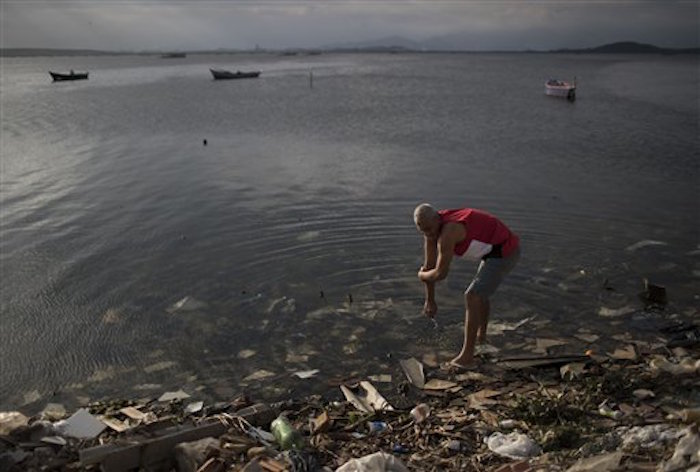 Un hombre se limpia en las aguas contaminadas de la BahÌa Guanabara en RÌo de Janeiro, Brasil. Foto: AP