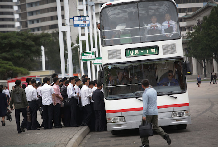 Un grupo de hombres montándose en un autobús para ir a trabajar. Foto: AP