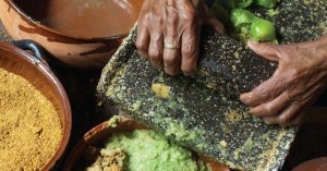 El uso generalizado del metate en los pueblos mesoamericanos se mantiene hasta nuestros días en las comunidades que no cuentan con acceso al suministro eléctrico. Fotografía: D.R. ©Adalberto Ríos, en Elogio de la cocina mexicana. Patrimonio Cultural de la Humanidad, México, Artes de México, 2012. 